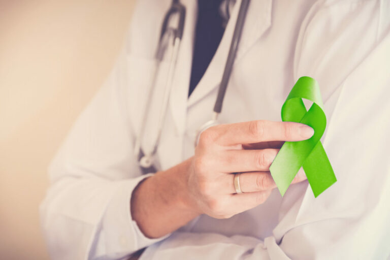 Physician holding a green ribbon in her hand