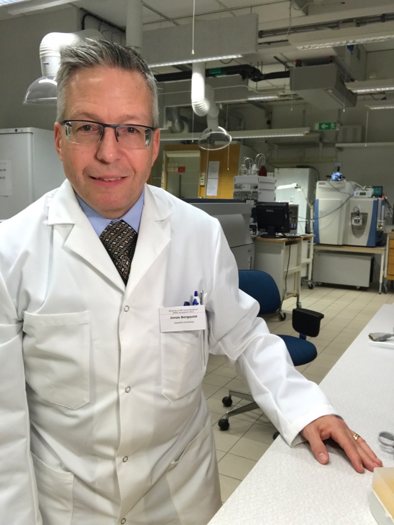 Jonas Bergquist wearing a lab coat, seated in a lab