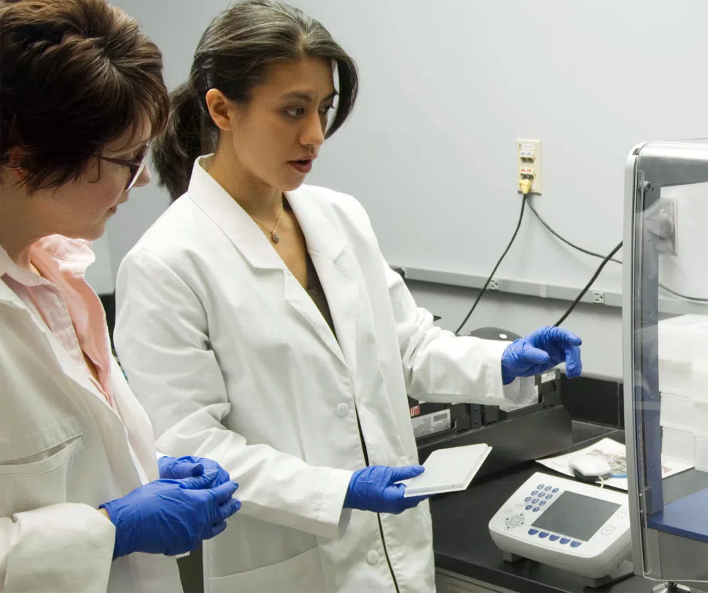 Two women researchers cooperating in a lab