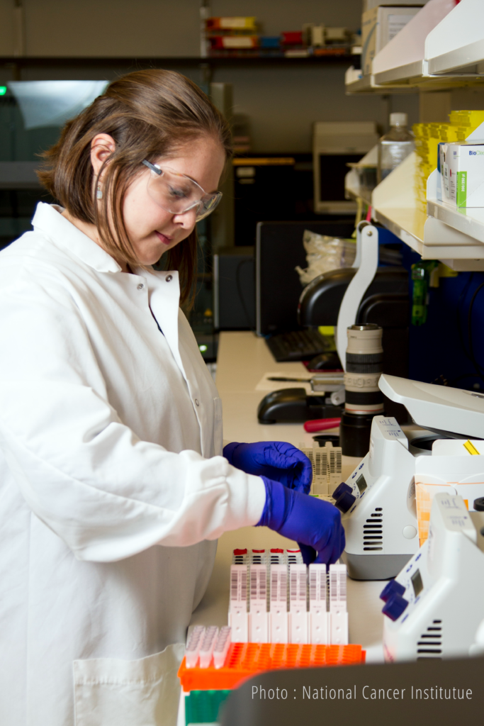 chercheuse en laboratoire avec des flacons