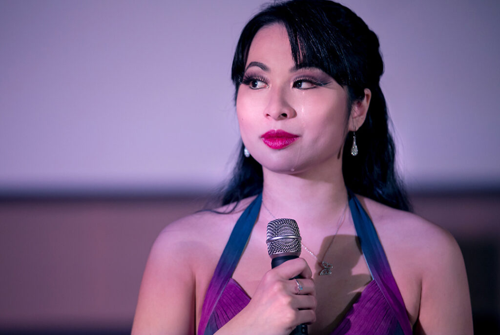 Jacqueline Ko, holding a microphone