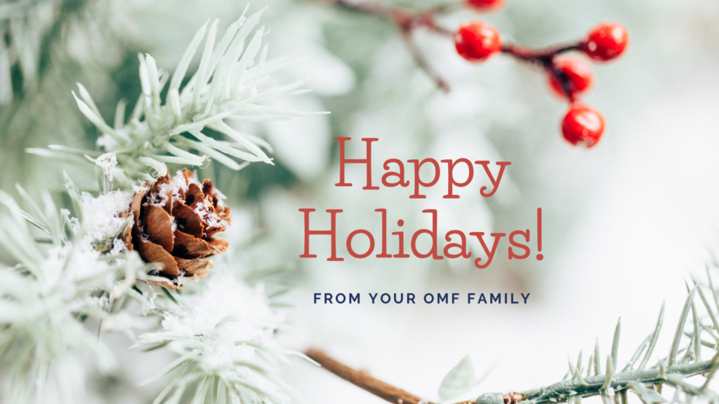 A pine cone and holly on a snow covered tree branch with the text, "Happy Holidays from your OMF family!"