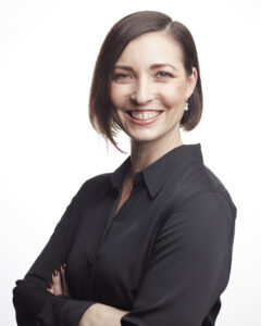 The image features Michelle James, PhD, who is smiling. She has short, dark hair and is wearing a black collared shirt.