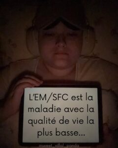 Alicia tient une pancarte disant : Le ME/SFC est la maladie avec la plus faible qualité de vie.