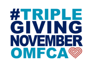 TGN logo: #TRIPLEGIVINGNOVEMBEROMFCA. The phrase is written in bold, uppercase letters with a mix of dark blue and light blue colors. The "OMFCA" text is in light blue, and there is a stylized heart shape in reddish-orange next to it.