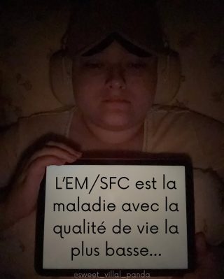 Alicia tient une pancarte disant : Le ME/SFC est la maladie avec la plus faible qualité de vie.